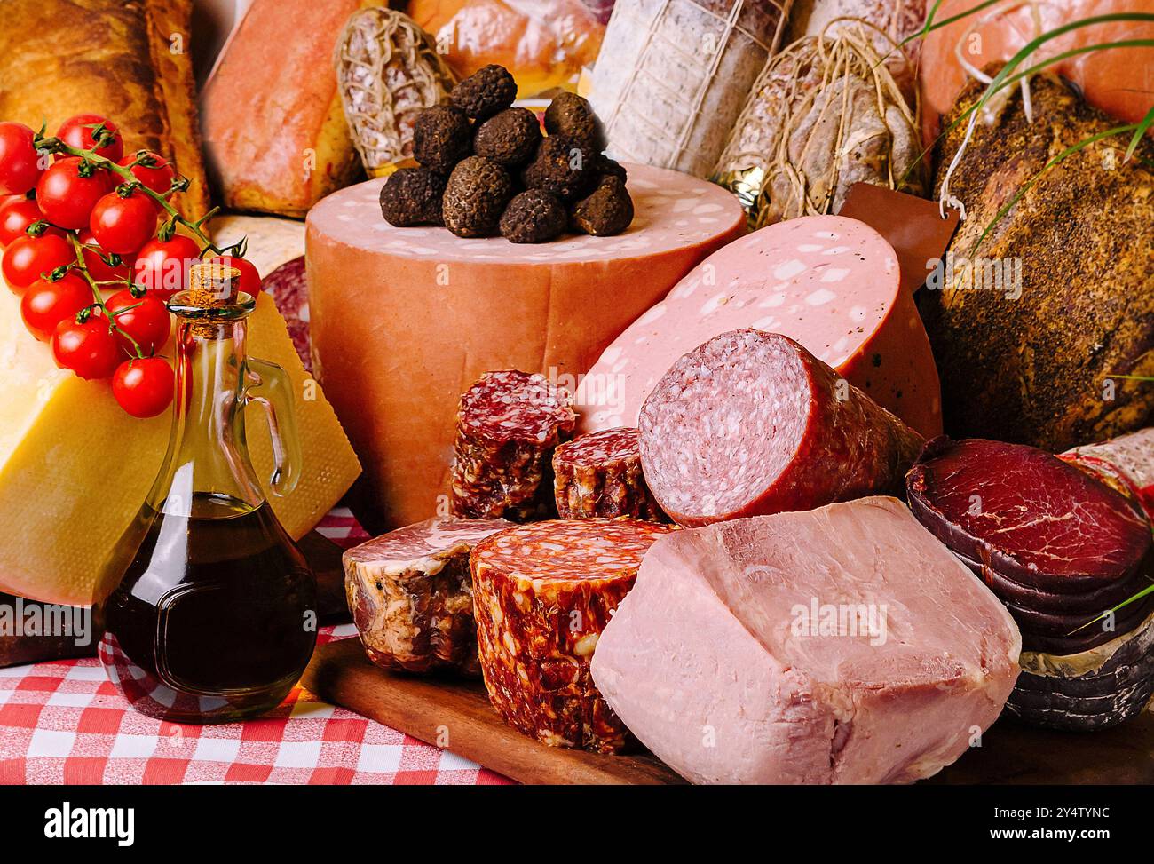 Kunstvoll arrangierte Auswahl an feinem Käse, Aufschnitt und Brot auf einer klassischen karierten Tischdecke Stockfoto