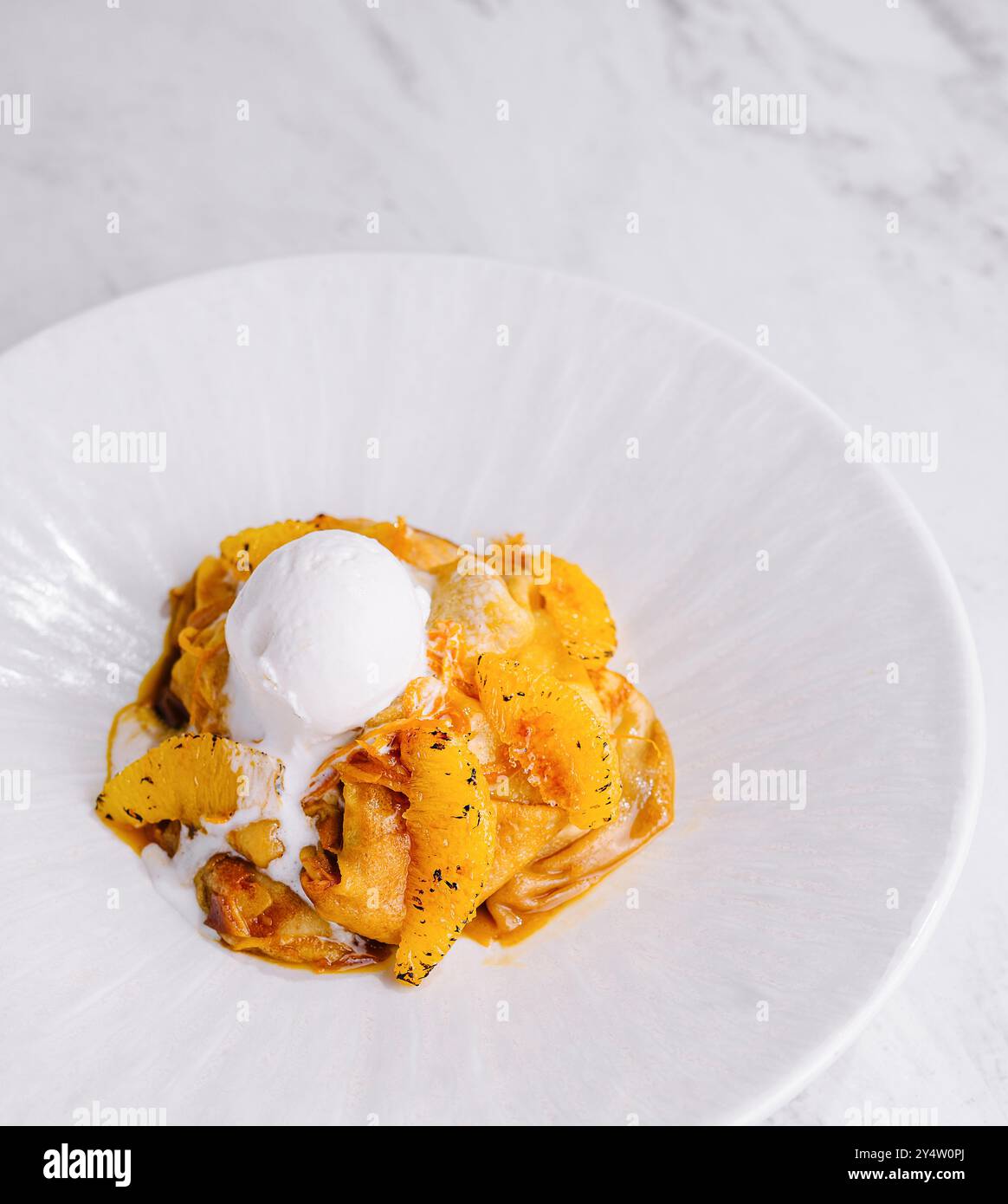 Eleganter Teller mit cremiger Pasta, gekrönt mit Zitrusnoten und einem Klecks Sahne Stockfoto