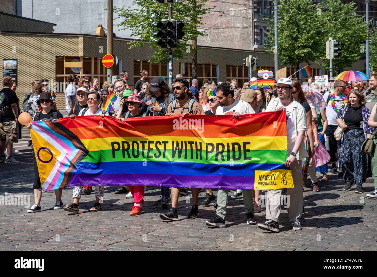 Protest mit Stolz. Amnesty International Progress Pride Fahnenbanner bei der Helsinki Pride 2024 Parade auf der Mannerheimintie in Helsinki, Finnland Stockfoto