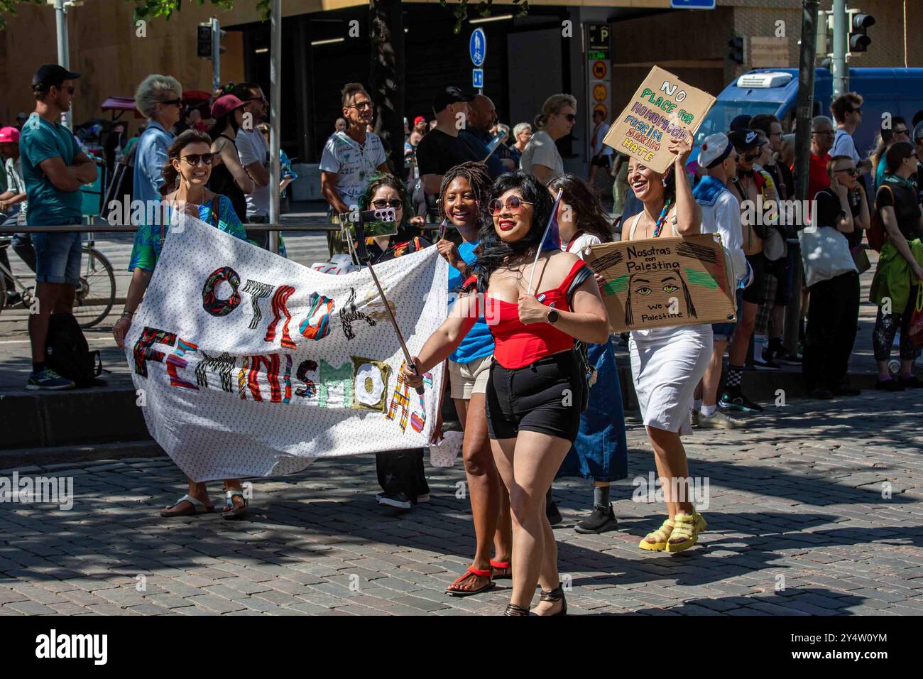 Intersektionale Feministinnen mit Otroas Feminismoas-Banner und Schildern bei der Helsinki Pride 2024-Parade in Helsinki, Finnland Stockfoto