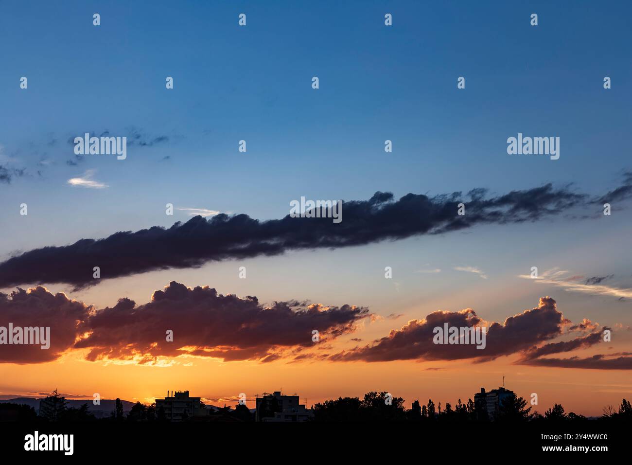 Sonnenuntergang mit dramatischem Himmel. Bewölkter Himmel bei Sonnenuntergang. Echter Himmel bei Sonnenuntergang, mit Sonnenstrahlen und wunderschönen Wolken. Stockfoto