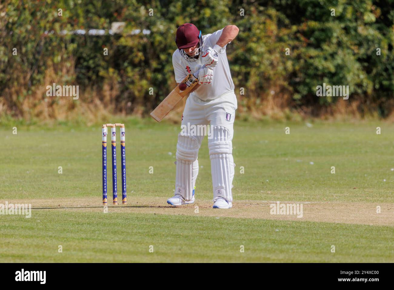 Der Newton Aycliffe Cricket Club war an einem sonnigen Samstagnachmittag Gastgeber des Middlesborough Cricket Club. Schlagmann schlägt den Ball Stockfoto