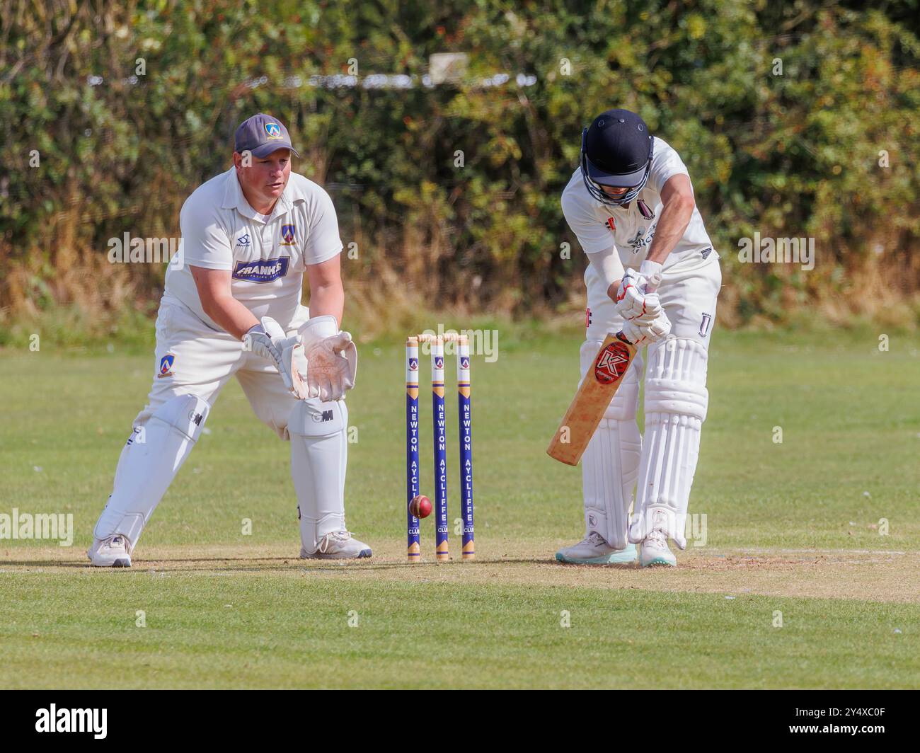 Der Newton Aycliffe Cricket Club war an einem sonnigen Samstagnachmittag Gastgeber des Middlesborough Cricket Club. Schlagmann schlägt den Ball nahe an den Wickets Stockfoto
