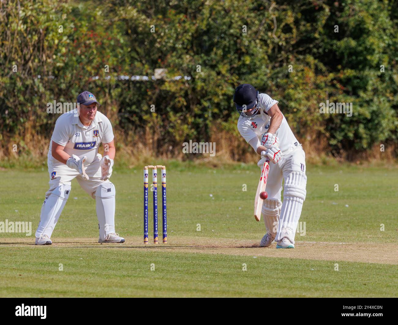 Der Newton Aycliffe Cricket Club war an einem sonnigen Samstagnachmittag Gastgeber des Middlesborough Cricket Club. Schlagmann schlägt den Ball Stockfoto