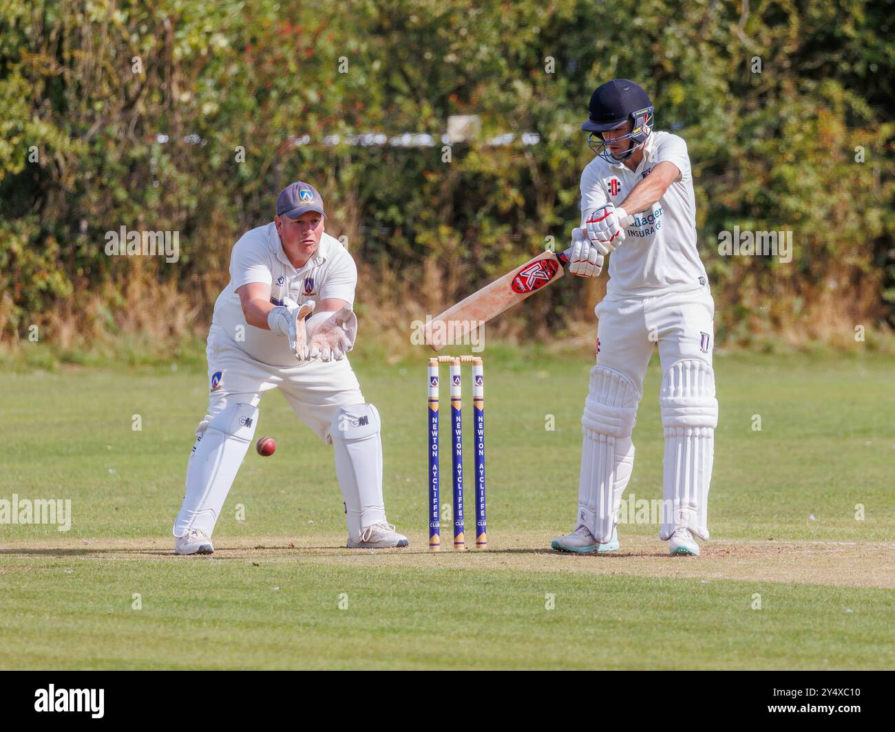 Der Newton Aycliffe Cricket Club war an einem sonnigen Samstagnachmittag Gastgeber des Middlesborough Cricket Club. Schlagmann schlägt den Ball in Richtung der Rutschen Stockfoto