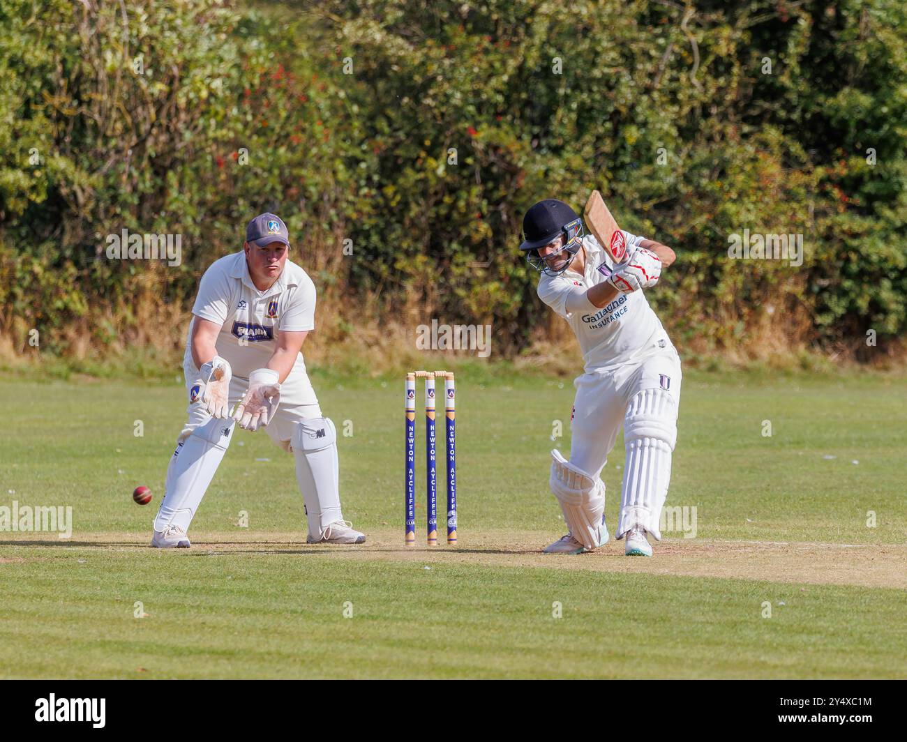 Der Newton Aycliffe Cricket Club war an einem sonnigen Samstagnachmittag Gastgeber des Middlesborough Cricket Club. Schlagmann schlägt den Ball in Richtung der Rutschen Stockfoto