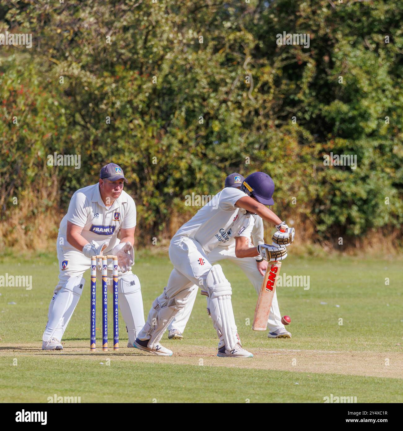 Der Newton Aycliffe Cricket Club war an einem sonnigen Samstagnachmittag Gastgeber des Middlesborough Cricket Club. Der Schlagmann spielt einen defensiven Schuss Stockfoto