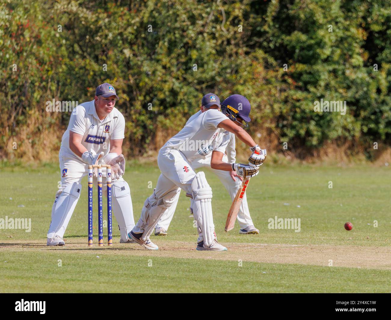 Der Newton Aycliffe Cricket Club war an einem sonnigen Samstagnachmittag Gastgeber des Middlesborough Cricket Club. Der Schlagmann spielt einen defensiven Schuss Stockfoto
