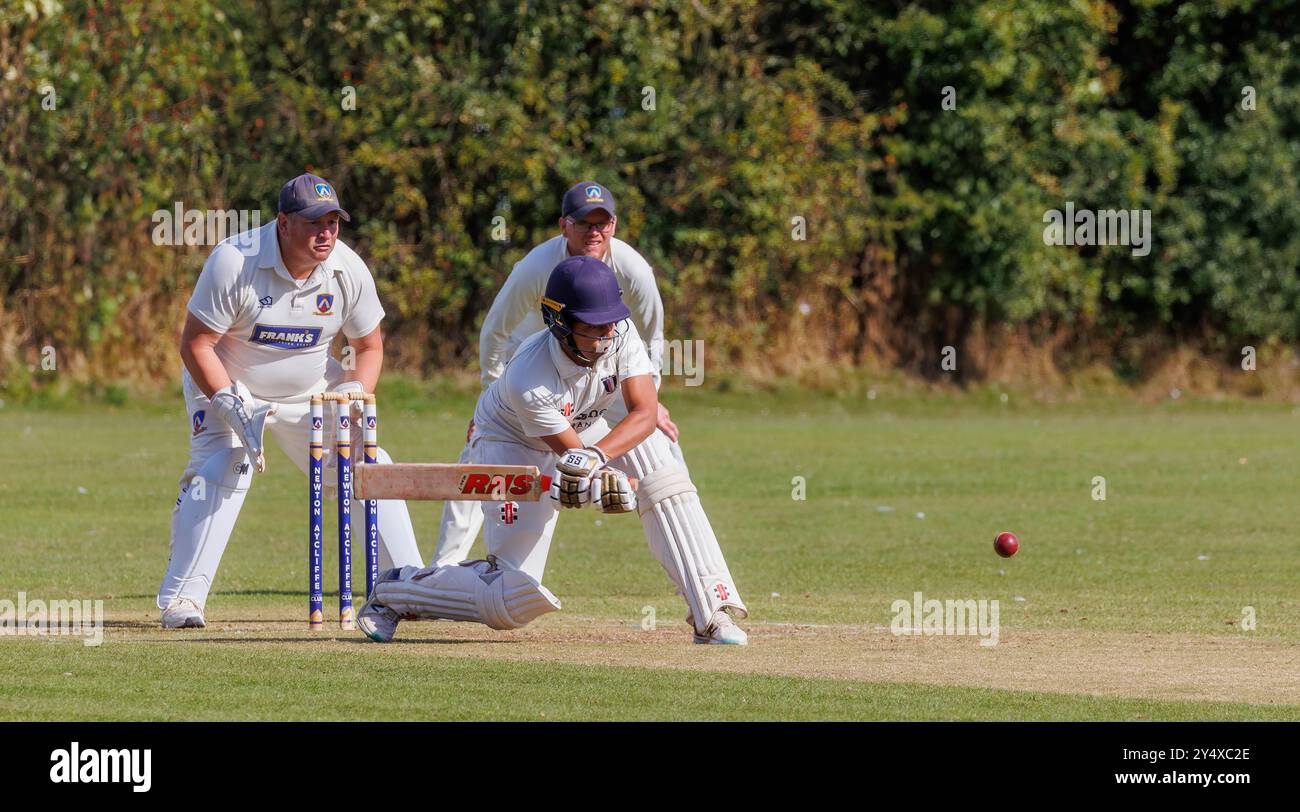 Der Newton Aycliffe Cricket Club war an einem sonnigen Samstagnachmittag Gastgeber des Middlesborough Cricket Club. Ein linksseitiger Schlagmann entscheidet sich für einen Rückwärtsfeger Stockfoto