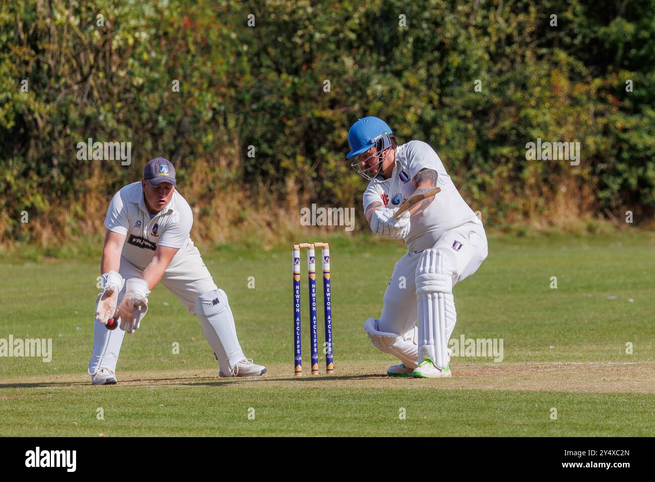 Der Newton Aycliffe Cricket Club war an einem sonnigen Samstagnachmittag Gastgeber des Middlesborough Cricket Club. Schlagmann und Wicket Keeper verpassen den Ball Stockfoto