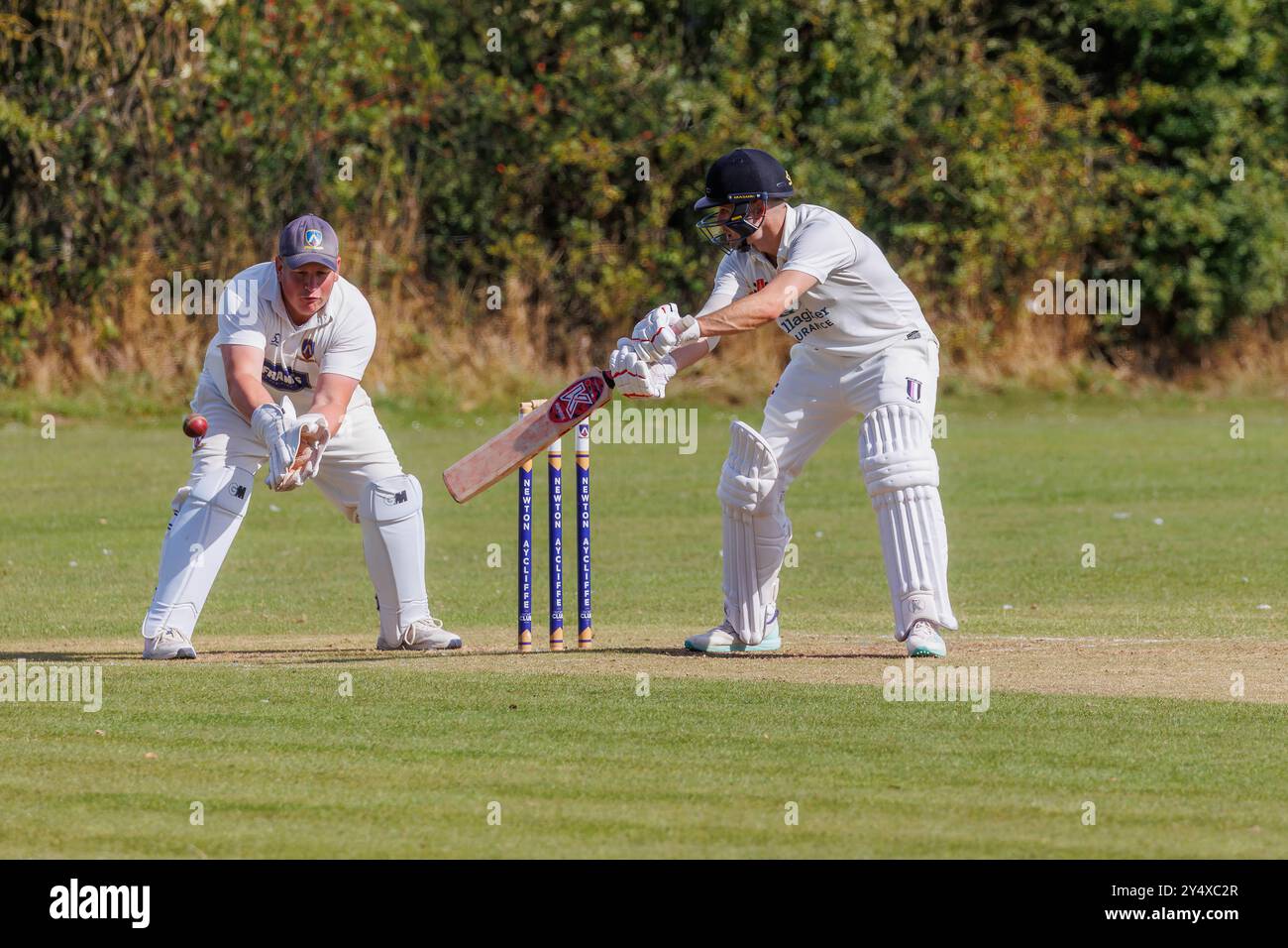 Der Newton Aycliffe Cricket Club war an einem sonnigen Samstagnachmittag Gastgeber des Middlesborough Cricket Club. Batsman spielt einen Schnitt auf die Ausrutscher Stockfoto