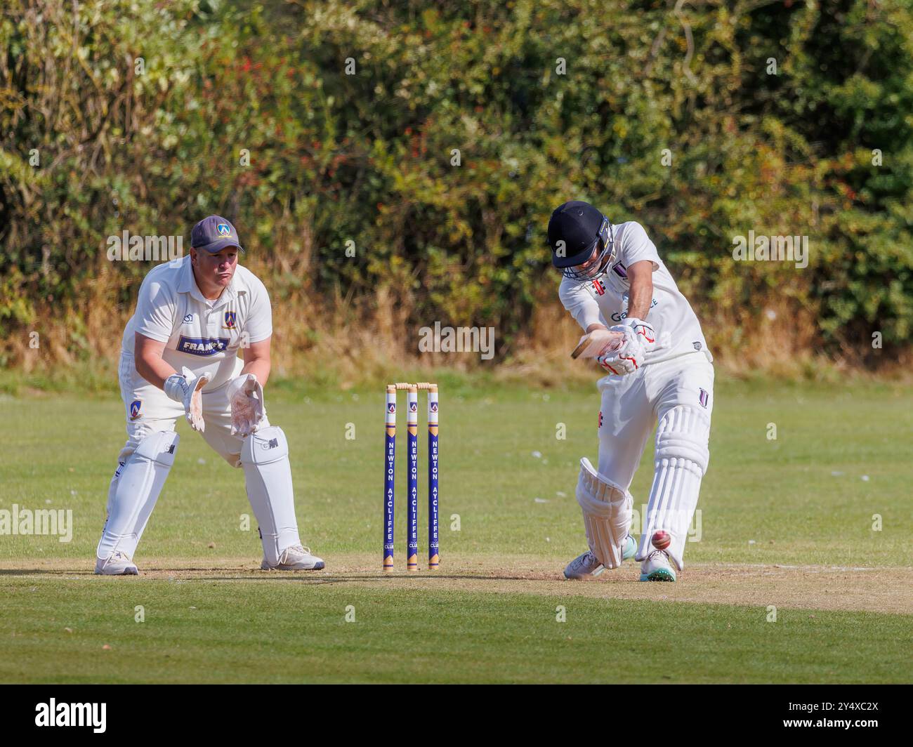 Der Newton Aycliffe Cricket Club war an einem sonnigen Samstagnachmittag Gastgeber des Middlesborough Cricket Club. Batsman treibt den Ball zurück ins Infield Stockfoto
