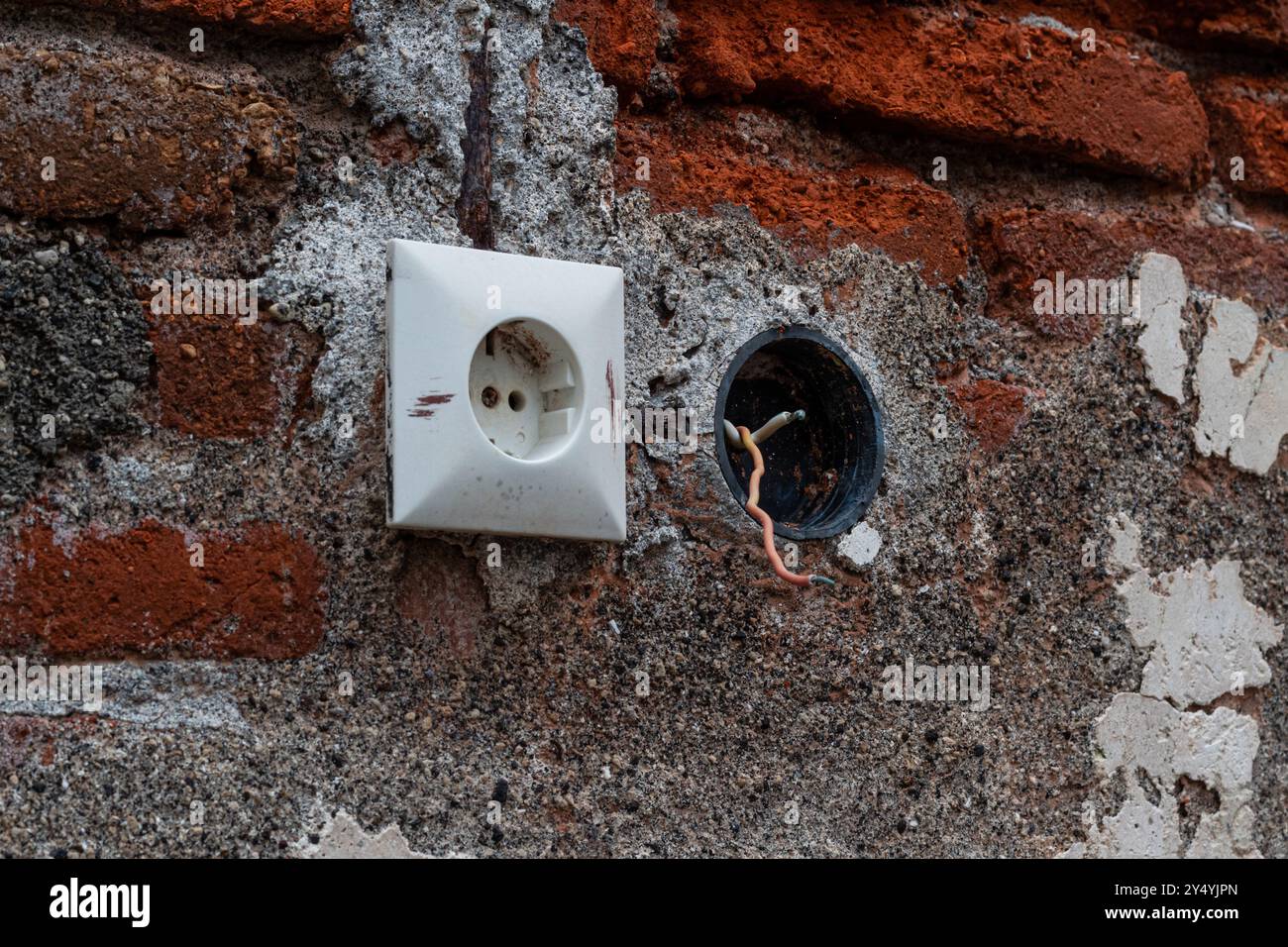 Elektrische Stecker in einer alten Ziegelwand Stockfoto