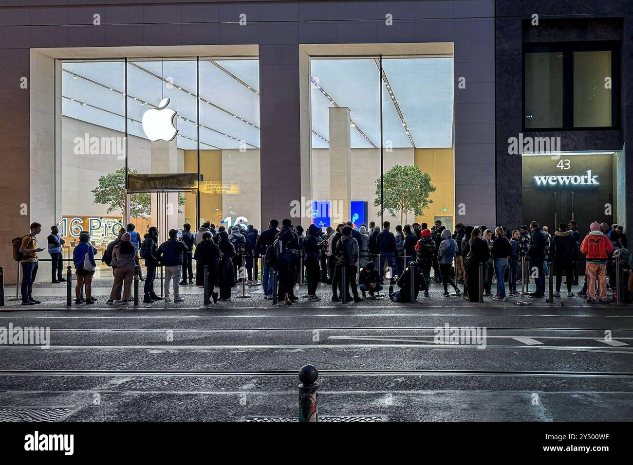 Berlin, Deutschland. September 2024. Passanten stehen vor dem Apple Store in Mitte. Hier beginnt der Verkauf der neuen iPhone 16- und iWatch 10-Modelle von Apple. Apple konzentriert sich bei seinen neuen iPhones auf bessere Kameras und künstliche Intelligenz. Die Nutzer in der Europäischen Union werden jedoch zunächst nicht viele der neuen KI-Funktionen nutzen. Quelle: Katharina Kausche/dpa/Alamy Live News Stockfoto