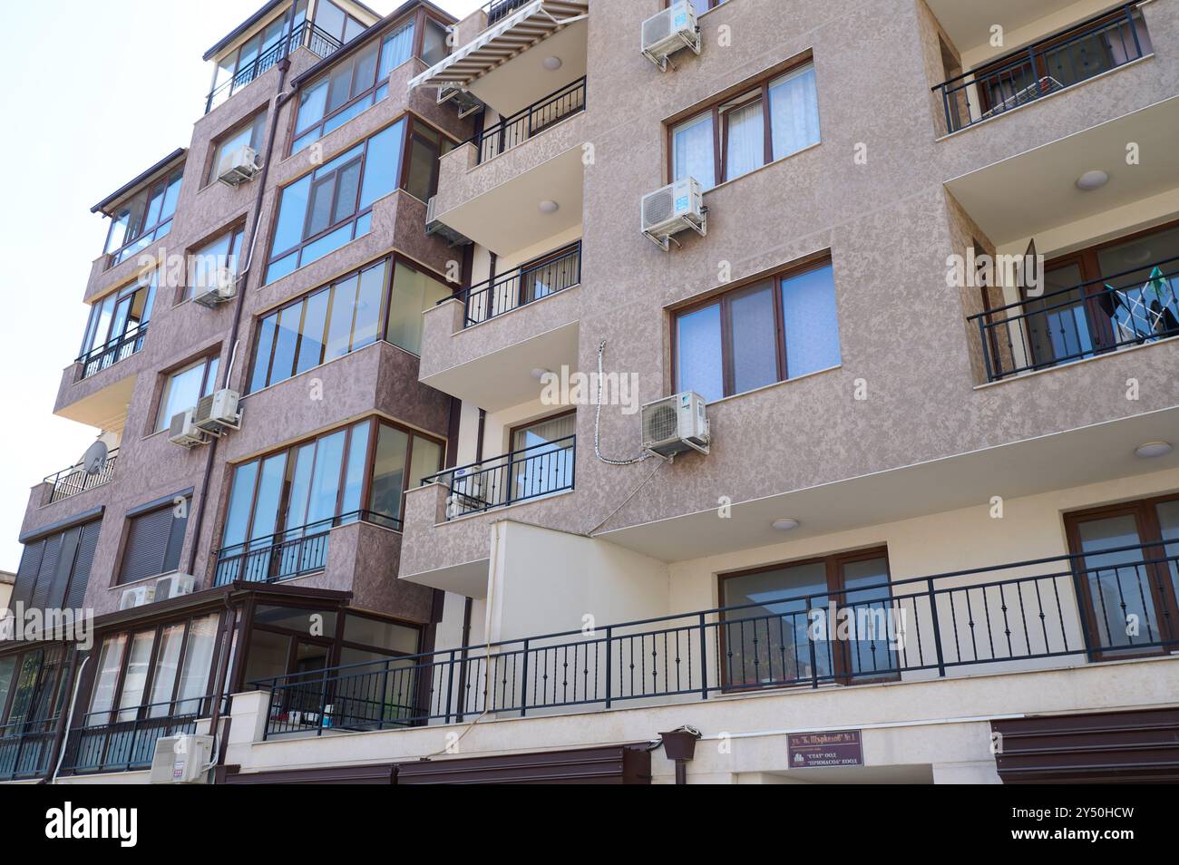 Ein modernes Wohngebäude entlang der Küste verfügt über große Fenster und Balkone, die viel Tageslicht und Platz im Freien bieten. Die Struktur Stockfoto