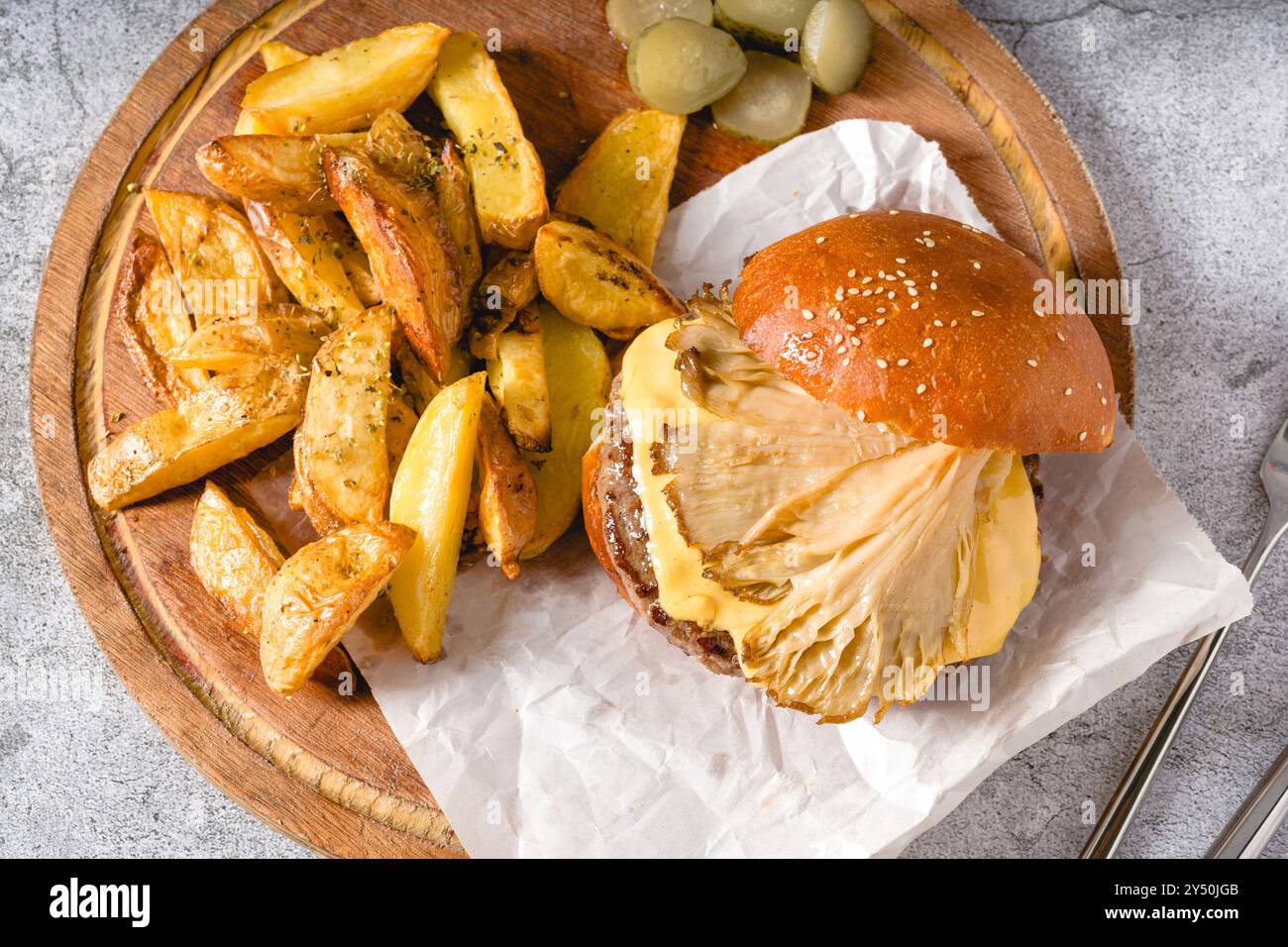 Hamburger mit Austernpilzen und Cheddar auf einem Holzschneidebrett Stockfoto