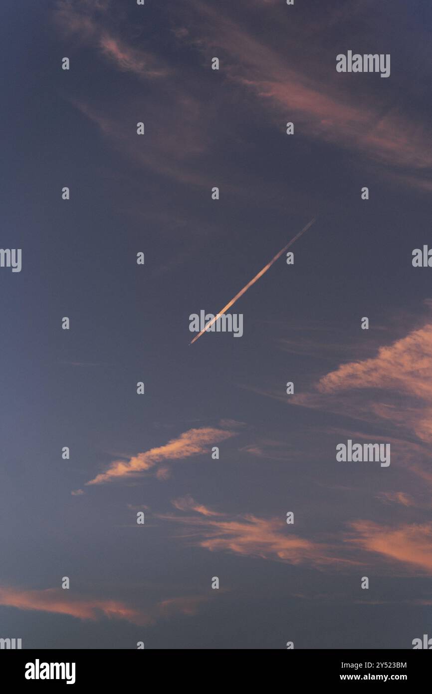 Das Flugzeug hinterlässt eine Spur am Sonnenuntergang. Stockfoto