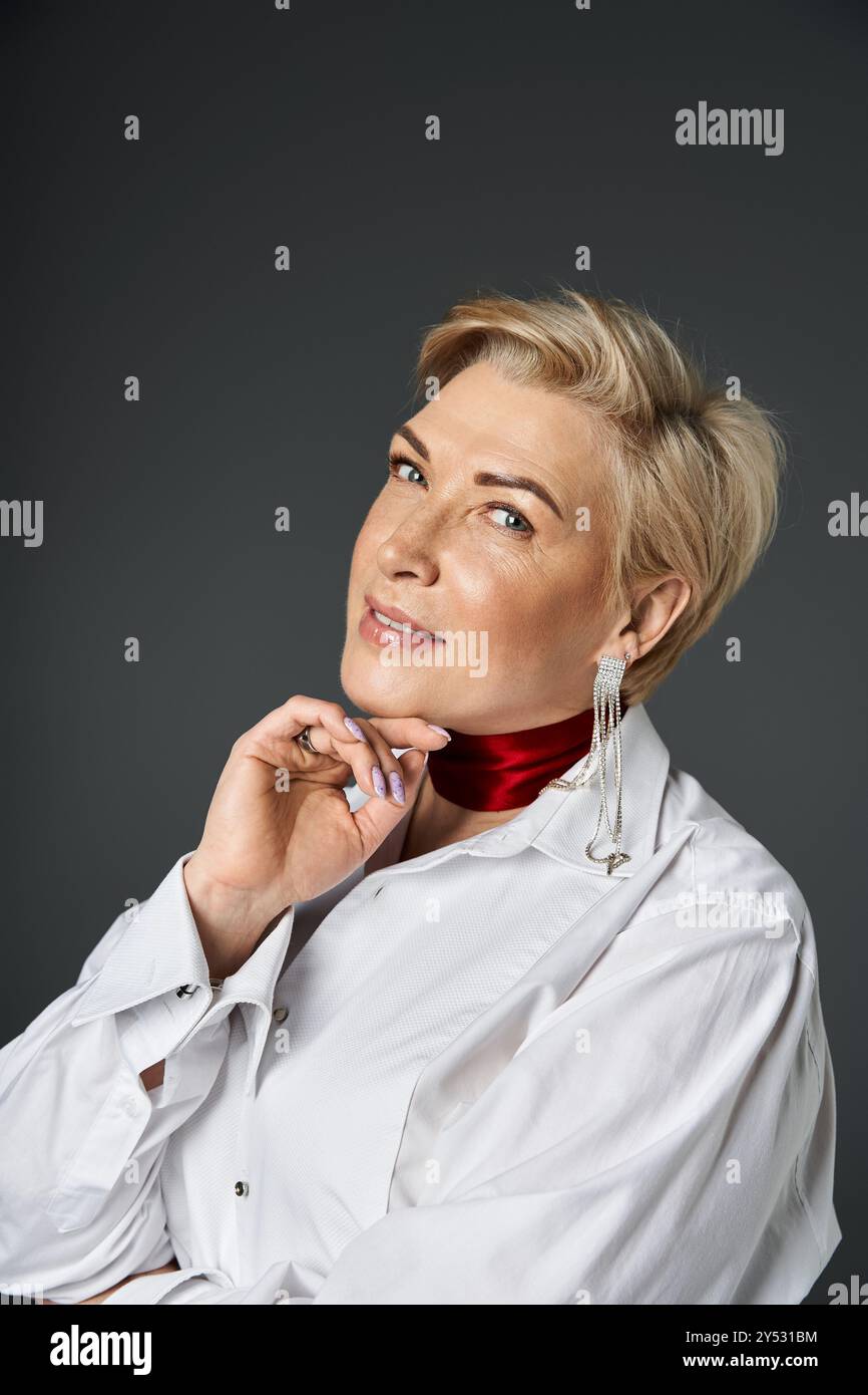 Eine modische Frau posiert selbstbewusst in eleganter Kleidung und auffälligen Accessoires. Stockfoto