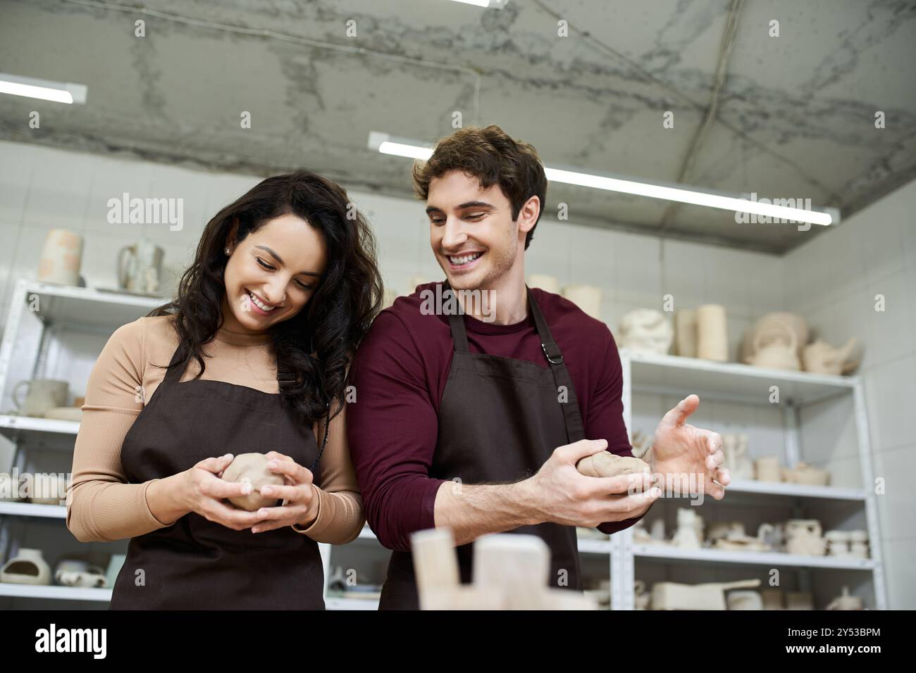 Ein Paar formt leidenschaftlich Ton und kreiert gemeinsam Kunst in einer zeitgenössischen Werkstatt. Stockfoto