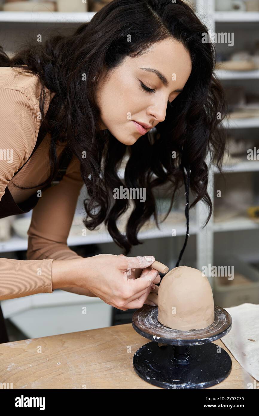 Gut gekleidete, stilvolle Frau mit Schürze, die Keramik macht. Stockfoto