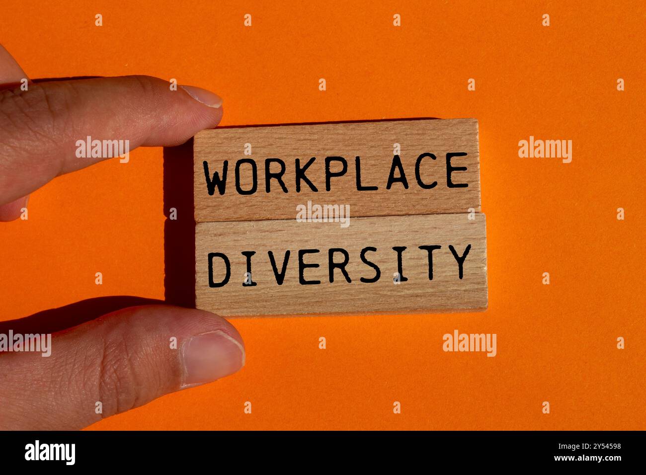 Botschaft zur Diversität am Arbeitsplatz auf Holzblöcken auf orangem Hintergrund. Symbol für konzeptionelle Vielfalt am Arbeitsplatz. Kopierbereich. Stockfoto