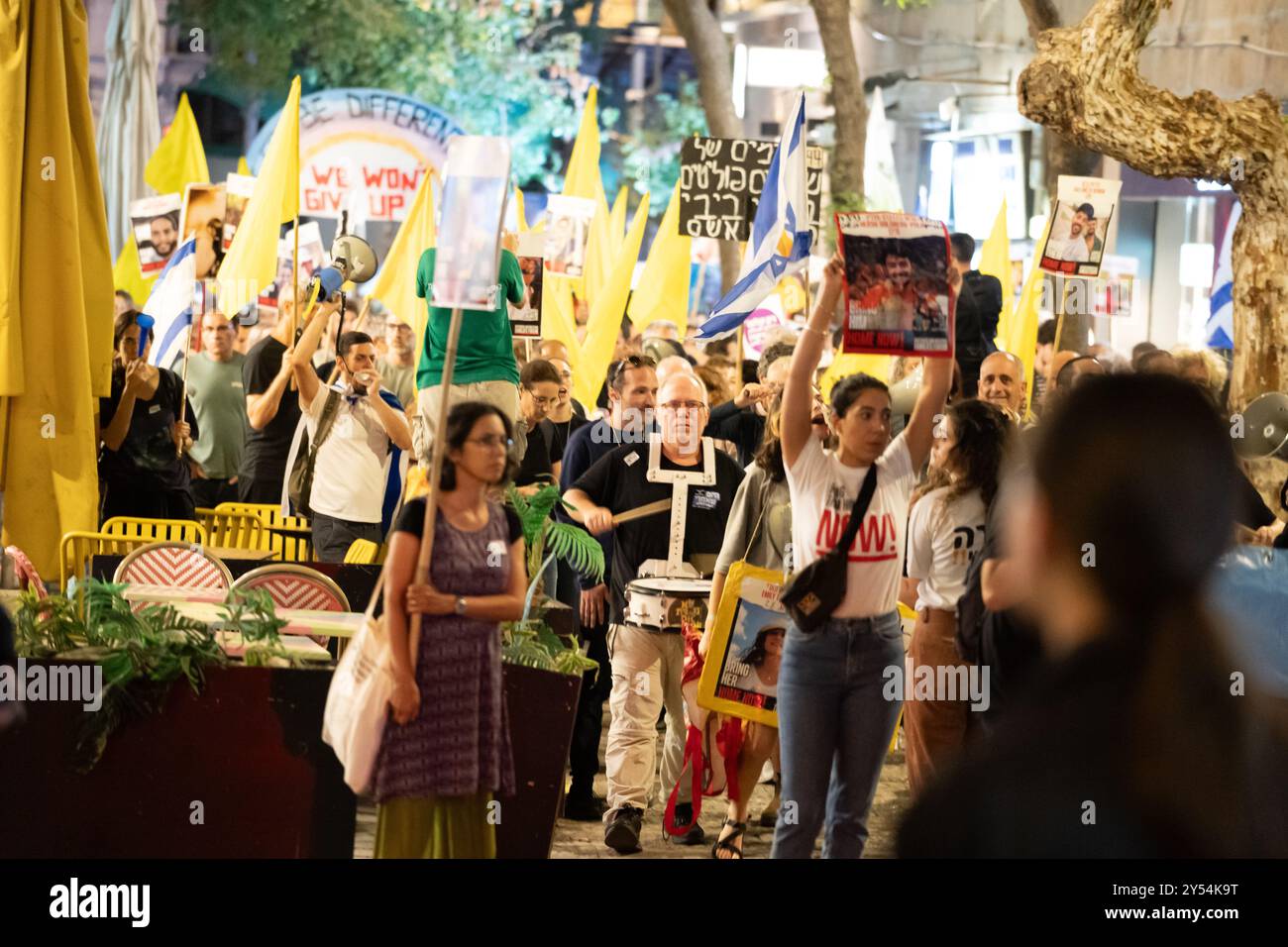 Die Demonstranten schwenken gelbe Fahnen und Schilder, die die Freilassung der Geiseln in Gaza fordern, während sie am 9/24 durch die Straße in Jerusalem marschieren Stockfoto