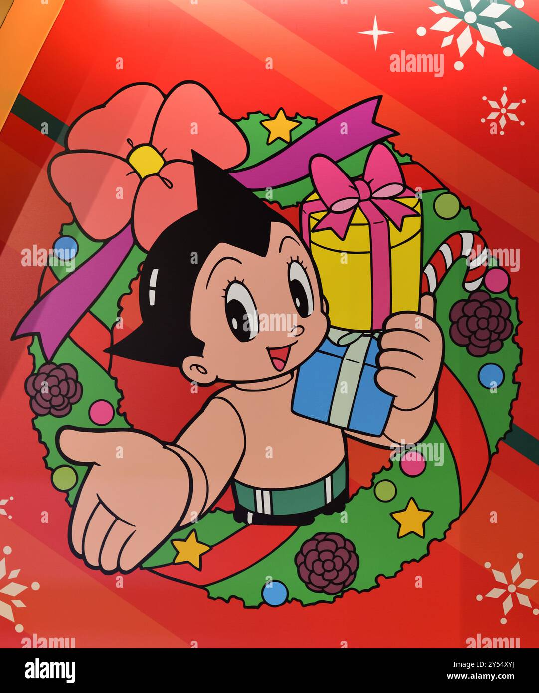 ASTRO Boy zeigt einladende Geste inmitten des Weihnachtskranzes Stockfoto