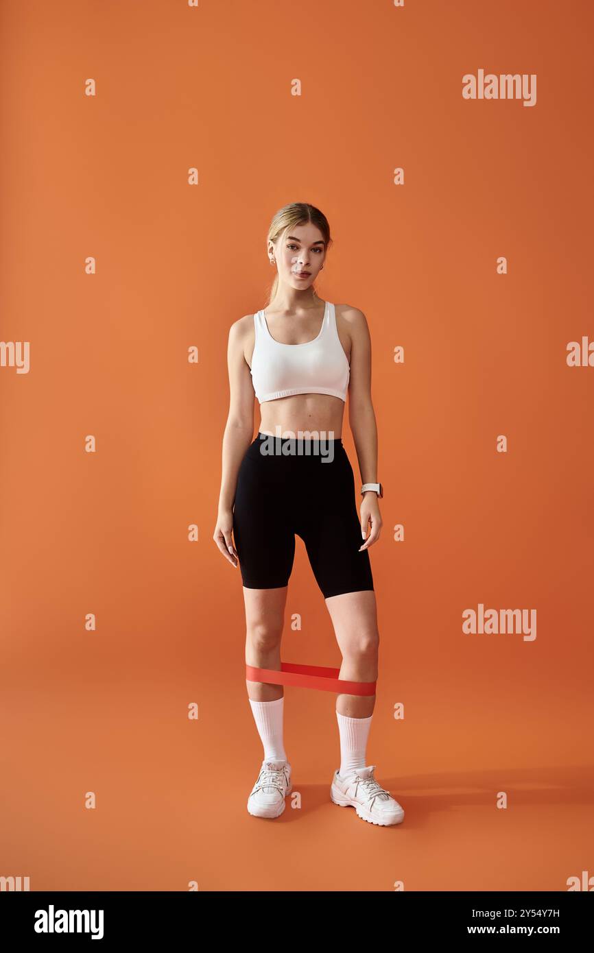 Eine Sportlerin zeigt ihre emotionale Kraft, während sie in Fitnessgeräten posiert. Stockfoto