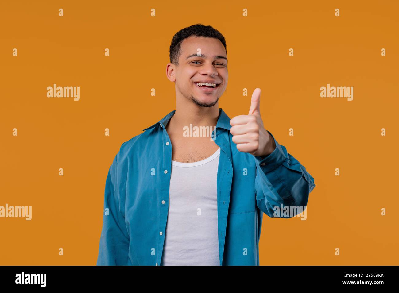 Positiver, stilvoller birassischer Mann mit ÄHNLICHEM Schild, Daumen hoch Geste. Happy Hipster. Stockfoto