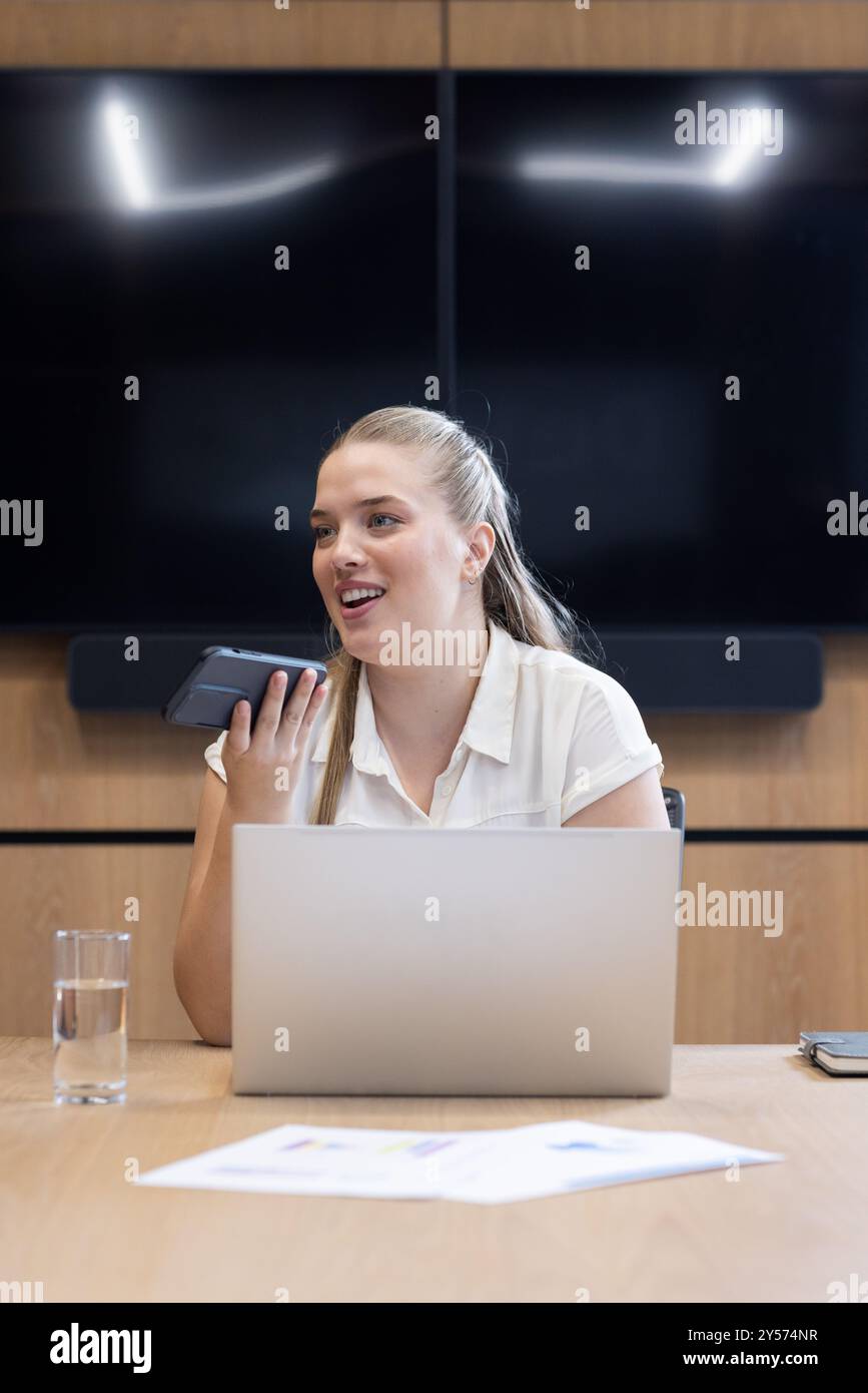 Mit Smartphone und Laptop, Frau, die geschäftliche Besprechungen im Büro durchführt Stockfoto