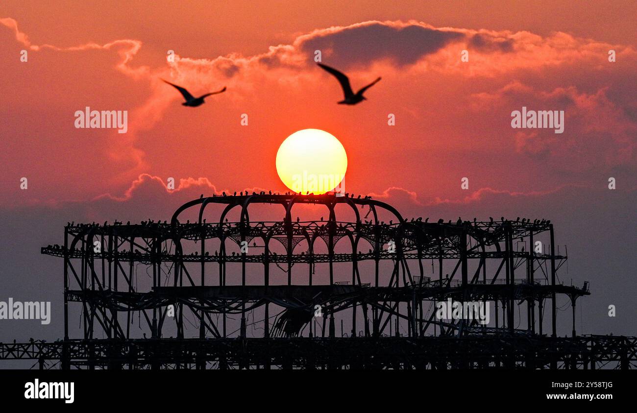 Brighton , Großbritannien 20. September 2024 - die Sonne geht heute Abend hinter dem West Pier in Brighton nach einem weiteren warmen, sonnigen Tag an der Südküste unter: Credit Simon Dack / Alamy Live News Stockfoto