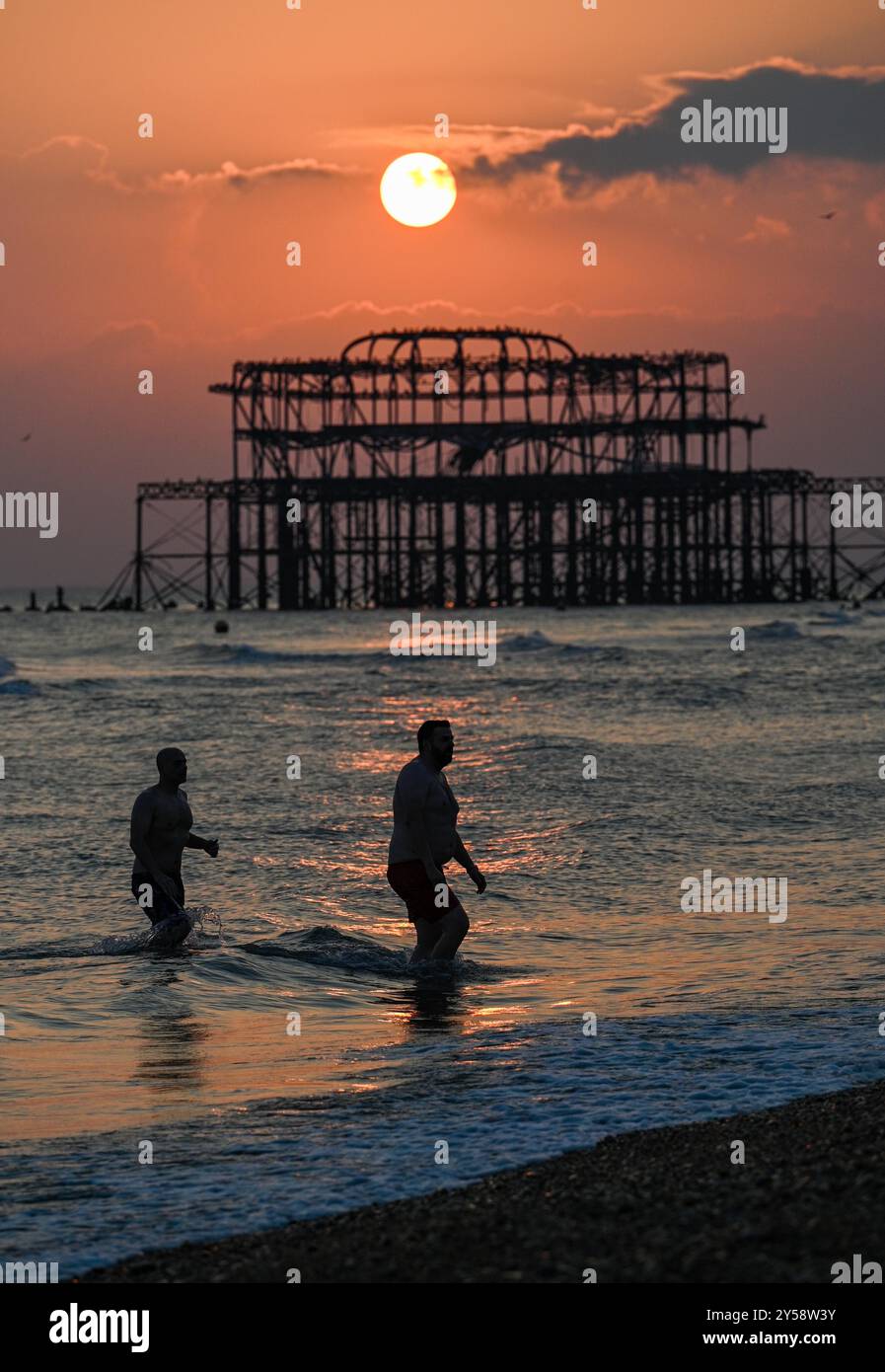 Brighton , Großbritannien 20. September 2024 - die Sonne geht heute Abend hinter dem West Pier in Brighton nach einem weiteren warmen, sonnigen Tag an der Südküste unter: Credit Simon Dack / Alamy Live News Stockfoto