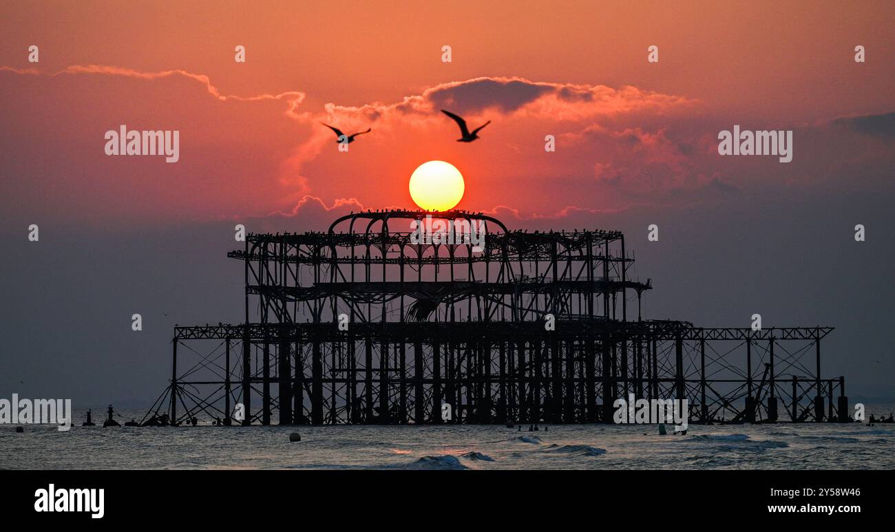 Brighton , Großbritannien 20. September 2024 - die Sonne geht heute Abend hinter dem West Pier in Brighton nach einem weiteren warmen, sonnigen Tag an der Südküste unter: Credit Simon Dack / Alamy Live News Stockfoto