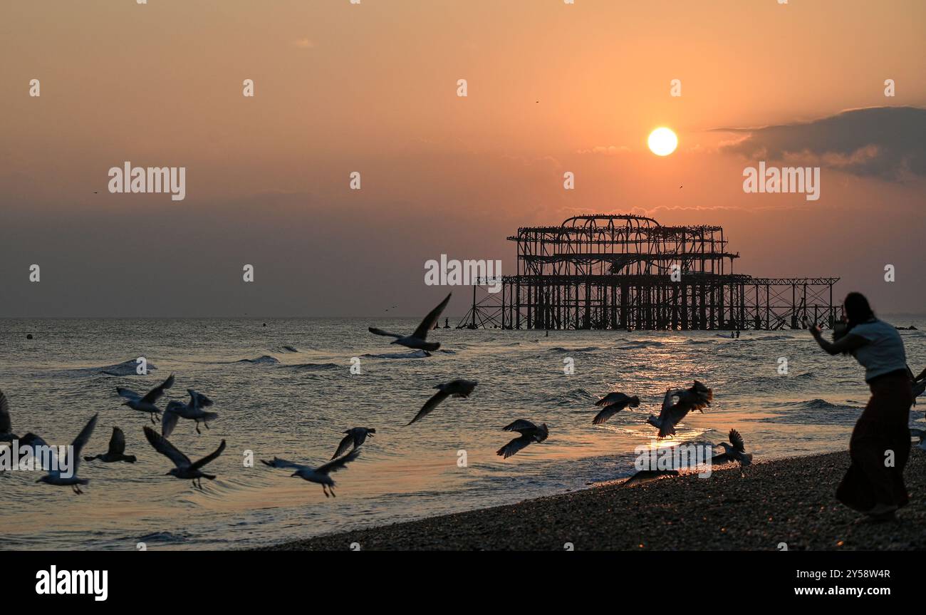 Brighton , Großbritannien 20. September 2024 - die Sonne geht heute Abend hinter dem West Pier in Brighton nach einem weiteren warmen, sonnigen Tag an der Südküste unter: Credit Simon Dack / Alamy Live News Stockfoto