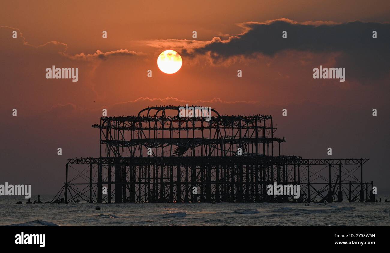 Brighton , Großbritannien 20. September 2024 - die Sonne geht heute Abend hinter dem West Pier in Brighton nach einem weiteren warmen, sonnigen Tag an der Südküste unter: Credit Simon Dack / Alamy Live News Stockfoto