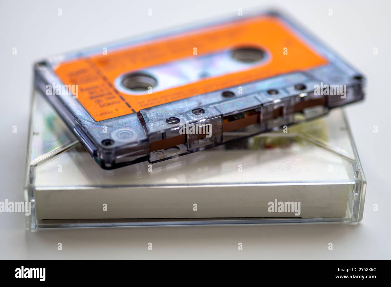 Nahaufnahme eines alten Musikkassettenbands und dessen Halterung in weiß isoliert. Stockfoto