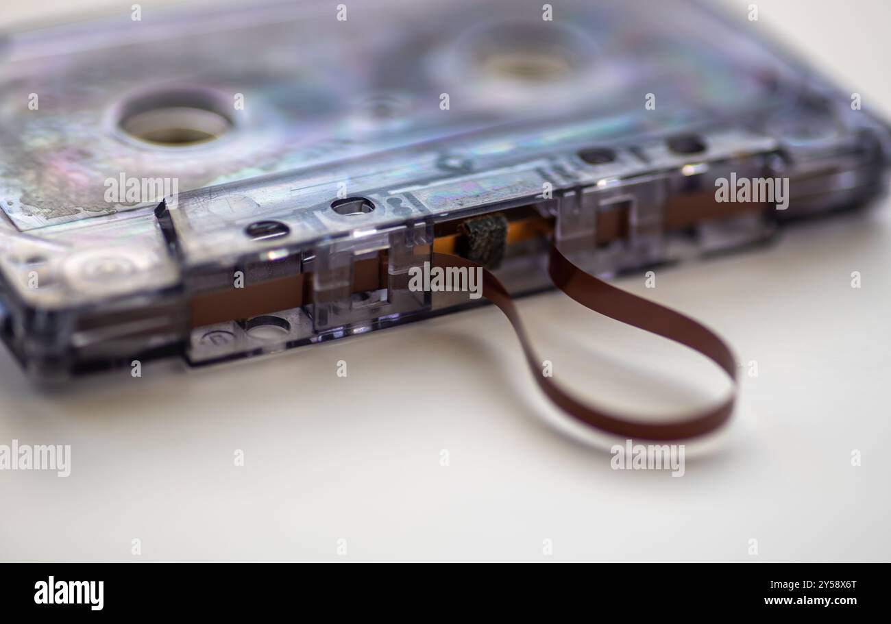 Nahaufnahme einer Musikkassette mit herauskommendem Band, isoliert auf weißem Hintergrund. Stockfoto