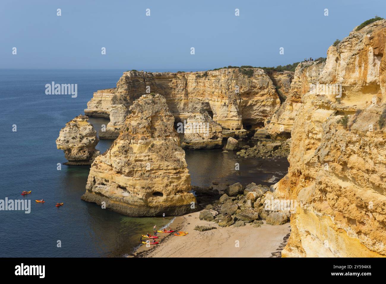 Majestätische Klippen treffen auf das ruhige Meer an einem sonnigen Tag mit einem goldenen Sandstrand und blauem Himmel, Praia da Marinha, Lagoa, Rocky Algarve, Algarve, Portugal, Eu Stockfoto