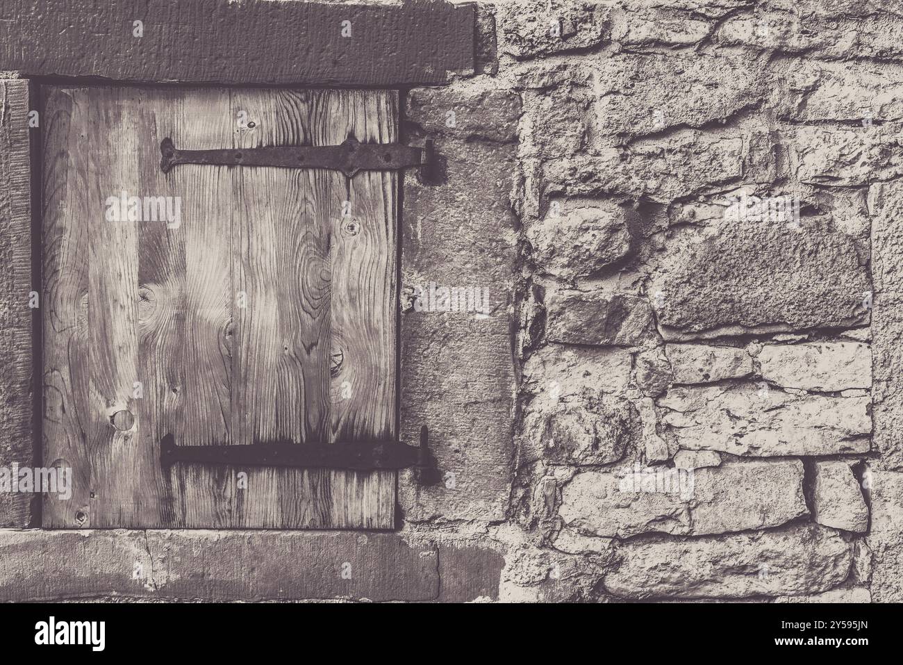 Architektonischen Rahmen mit einem verwitterten hölzerne Falltür und die Steinmauer aus einem traditionellen deutschen Haus Stockfoto