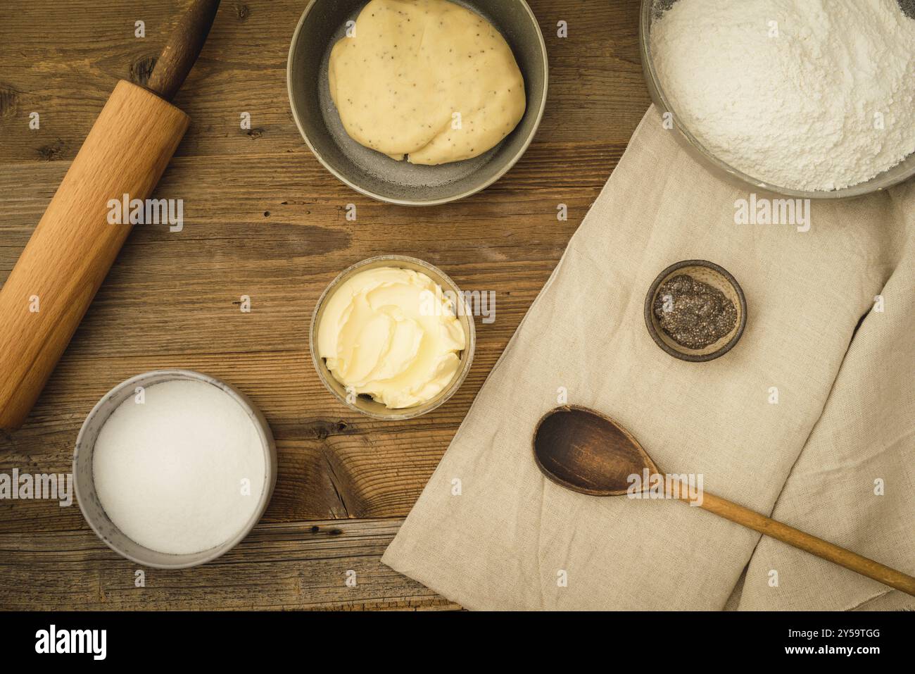 Sammlung von Zutaten und Utensilien zum Backen von veganen Keksen mit Margarine und Chia als Eierersatz auf dunklem Holzboden Stockfoto