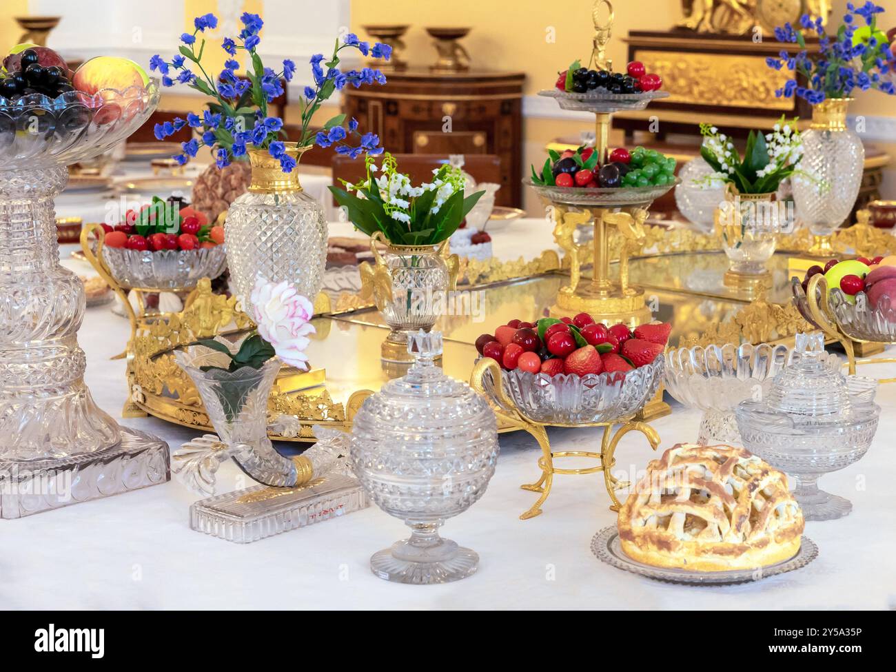 Erdbeeren in einer Kristallvase auf einem reich verzierten Tisch. Option „Tischeinstellung“. Stockfoto