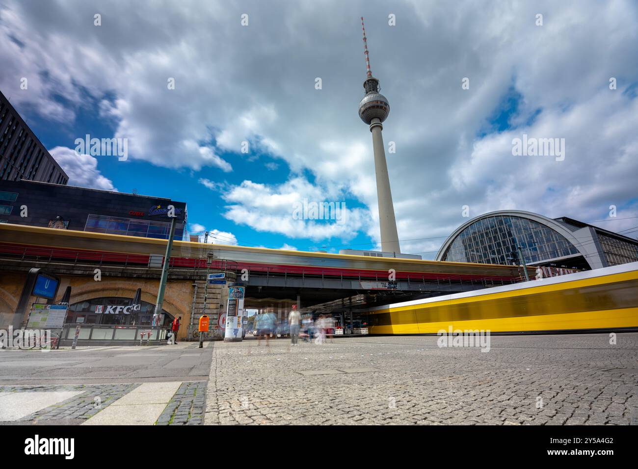 Berlin - 23. Juni 2024: Bahnhof Alexanderplatz. Fernsehturm im Hintergrund. Sonniger Tag, mittelbewölkter Himmel. Stockfoto