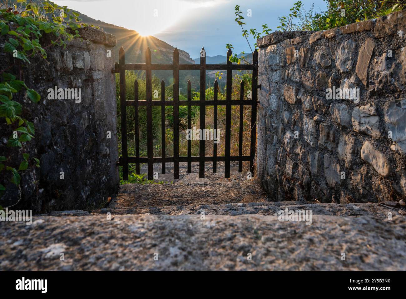 Abendsonnenstrahlen durch ein altes Tor über einem Berg - Hoffnung für das Zukunftskonzept Stockfoto