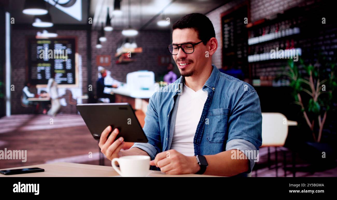 Hispanischer Mann Mit Tablet Im Café Oder Café Stockfoto