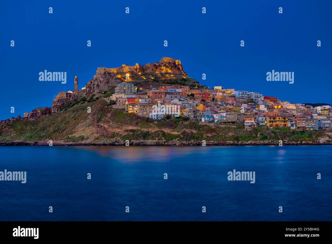 Häuser in der kleinen Küstenstadt Castelsardo, dominiert von der Burg Doria, die nachts den Hafeneingang überblickt. Castelsardo Sardinien Italien Stockfoto