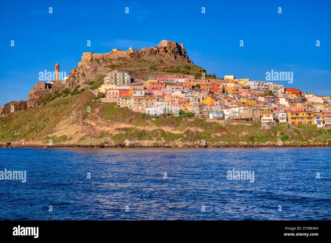 Häuser in der kleinen Küstenstadt Castelsardo, die von der Burg Doria dominiert wird, die den Hafeneingang überblickt. Castelsardo Sardinien Italien FB 2024 2 Stockfoto