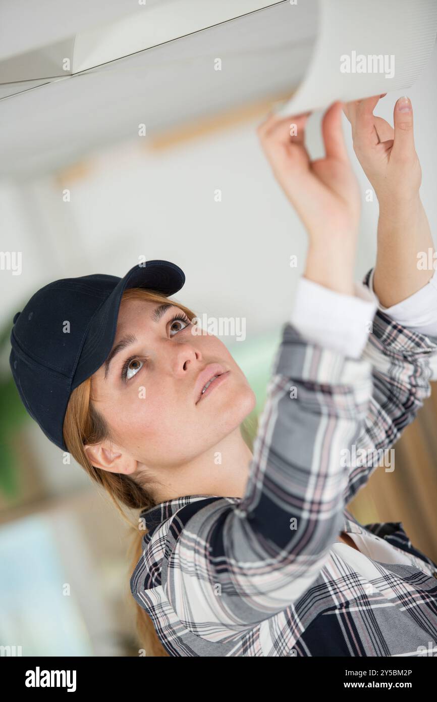 Frau arbeiten an der Decke Stockfoto