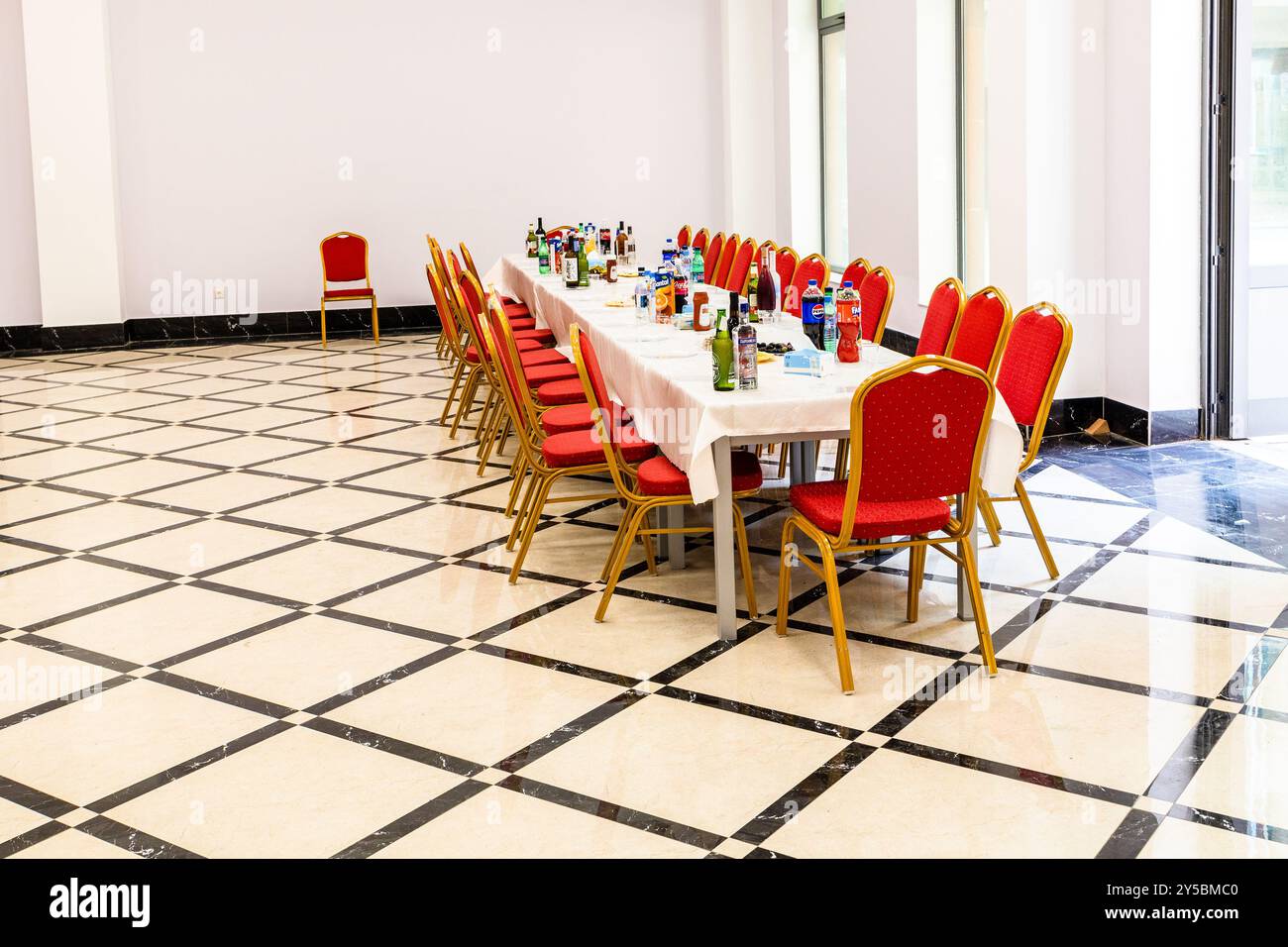 Jerewan, Armenien - 10. September 2024: Serviert lange Tische und rote weiche Stühle im Flur vor der Firmenfeier Stockfoto