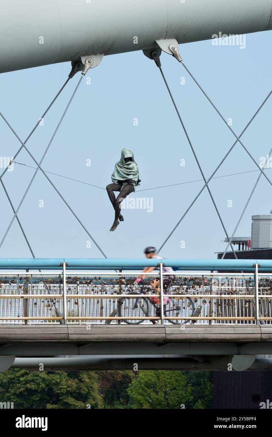 Pater Bernatek Fußgängerbrücke mit Radweg - Hängefigur, Teil der Skulptur Jerzy Kedziora mit Blick auf Radfahrer - Krakau Polen Stockfoto