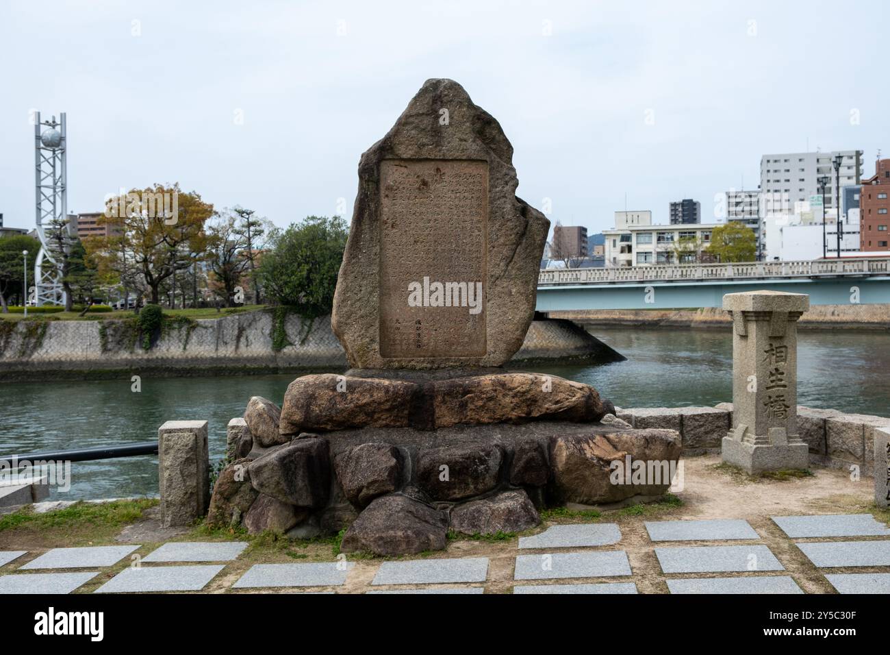 Hiroshima Peace Memorial Park, Japan. Memorial großer Felsen mit japanischem Text am Flussufer Stockfoto